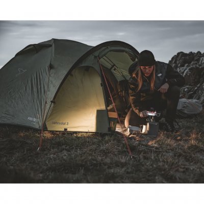 Setesdal 3 kuppeltelt i naturmiljø, en person lager mat foran teltet i mørket med koselig atmosfære.