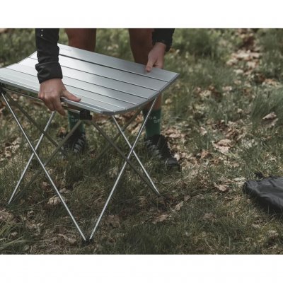 Bordet har en avtakbar bordplate bestående av lameller/plater som rulles sammen.